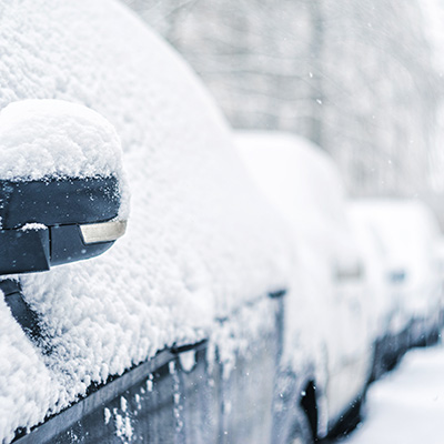 cars on side of road covered in snow